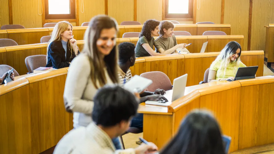Ny universitets- og høyskolelov har trådt i kraft i Norge Gruppe studenter i et auditorium som studerer og diskuterer sammen.