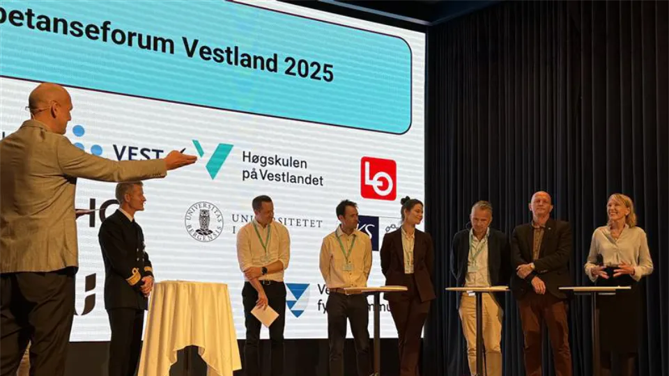 Kompetanseforum Vestland Paneldebatt på scene under Kompetanseforum Vestland 2025 med flere deltakere og presentasjonsskjerm i bakgrunnen.